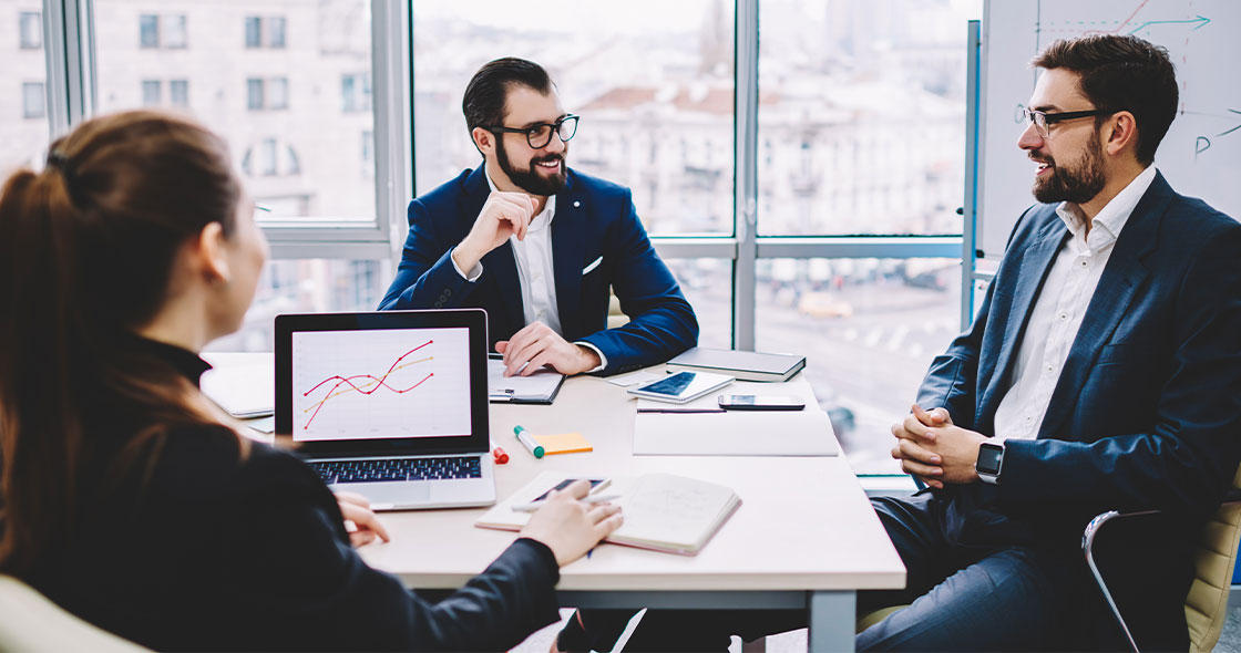 3 Geschäftsleute beim Meeting mit Laptop und Unterlagen
