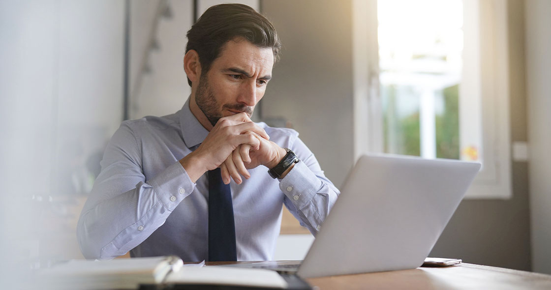 Junger Mann am Laptop symbolisiert Investor für Firma finden
